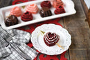 red heart-shaped cakelet, displayed on a white plate.