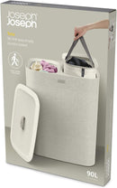 Joseph Joseph ecru 90-liter dual laundry hamper with removable fabric bags and lid, displayed on a white background.