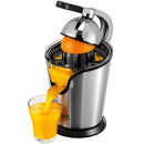 A brushed stainless steel citrus juicer with a black handle, actively juicing an orange into a glass of orange juice.