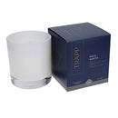 Trapp No. 77 Palo Santo 7 oz. Signature Candle in a frosted white glass container, placed next to its navy and gray packaging.