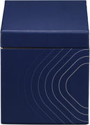 A lighted, white scented candle in a clear glass votive, positioned next to its dark blue, house-shaped packaging box. The box features the "TRAPP FRAGRANCES" logo in gold, and a label indicating "No. 13 BOB'S FLOWER SHOPPE™" with scent notes of "FRESH FLORALS, CUT GREEN STEMS, WATERY ACCORDS." The candle is a "FRAGRANCED CANDLE 7 oz | 198g ℮".