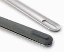 A stainless steel knife, fork, and spoon with black and silver handles, next to a translucent white rigid case. The handles are designed to fit together for compact storage.