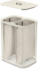 Joseph Joseph ecru 90-liter dual laundry hamper with removable fabric bags and lid, displayed on a white background.