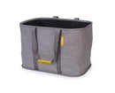 A gray Joseph Joseph Hold-All Max collapsible laundry basket with a yellow tag and gray fabric handles. The basket has a moisture-resistant black interior.