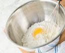 Medium-sized stainless steel mixing bowl, perfect for mixing ingredients, angled view on white background