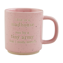 A pink speckled stoneware coffee mug with the embossed text: 'i live in a madhouse run by a tiny army that i made myself.'.