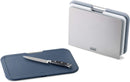 A set of three rectangular cutting boards in gray and white, stored vertically in a silver stand. The boards feature metal handles and non-slip feet.