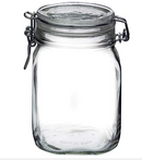 An empty, clear glass Fido jar with a glass lid and a metal wire clamp closure for an airtight seal.
