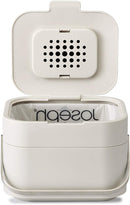 A ventilated, rectangular Joseph Joseph compost bin with the lid open, showing the built-in odor filter and a compostable liner inside.