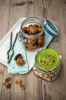 An empty, clear glass Bormioli Rocco Fido square-shaped jar with a vibrant blue lid insert and a metal wire clamp closure.
