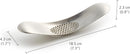 A sleek, stainless steel garlic press with a unique curved shape and perforated crushing surface.