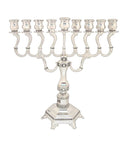 A nine-branched Menorah with a polished nickel finish, ornate, curving arms, and a decorative octagonal base.