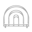 A silver chrome metal napkin holder with a curved, arched design and small ball feet.