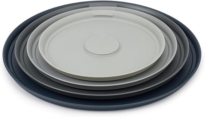 A set of four stainless steel mixing bowls with a brushed finish, nested neatly inside each other, with a dark non-slip base on the outer bowl.