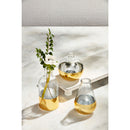 A small, round, orb-shaped vase. The top half is clear hammered glass, and the bottom is a wide, hand-painted gold band.