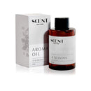 A 100ml bottle of SCENT New York Aroma Oil in the '4 Seasons' fragrance. The amber glass bottle features a minimalist white label with black text and a black cap. Next to the bottle is its matching packaging box, which shares a similar white and black design with subtle floral artwork on the side.
