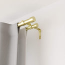Two brushed brass curtain rods, one thicker and one thinner, both with simple, cylindrical end caps.