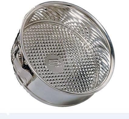 A round, metallic springform pan with a textured, fluted base and a quick-release latch on the side.