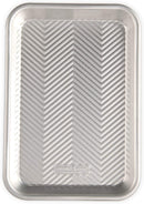 Nordic Ware Prism eighth sheet baking pan with embossed grid pattern and silver aluminum finish on a white background