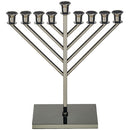 A modern Chabad Menorah with a blackened nickel finish. It has nine candle holders in a geometric, V-shaped design and a rectangular base.