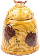A whimsical ceramic honey pot designed like a yellow beehive with textured walls, featuring two dark brown bees on its exterior and a fitted lid with a small bee on top.