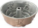 Nordic Ware copper rose-shaped Bundt pan with petal detailing and center tube on a white background.