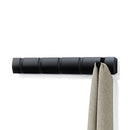 Black Umbra Flip 5 Hook wall-mounted coat rack with retractable hooks on a white background.