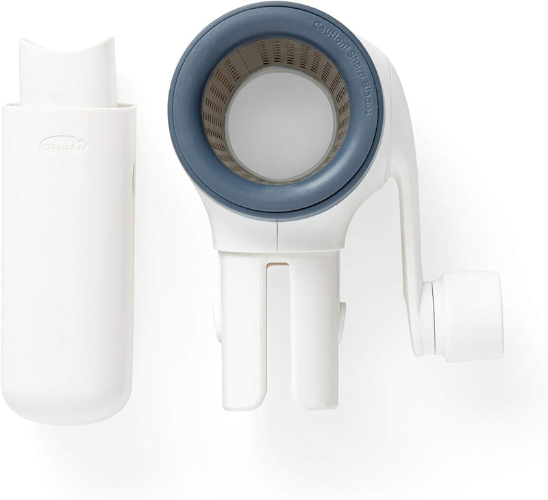 Chef'n spring-loaded rotary grater in white with blue accents, shown with a removable grating drum, designed for easy cheese grating.