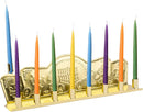 A shiny gold tin candle menorah with intricate designs of coins, a dreidel, and a temple, perfect for celebrating Hanukkah.