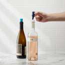 Two sets of packaged Houdini silicone wine stoppers. One package contains navy blue and bright blue stoppers, and the other contains burgundy and light pink stoppers.