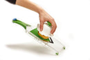 Green handheld Farberware mandoline slicer with stainless steel blade.