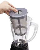 A Hamilton Beach blender with a brushed stainless steel and black base, a clear Tritan jar filled with fruits and ice, and a removable gray mesh strainer/chopper insert.