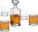 A crystal whiskey decanter with four matching glasses arranged neatly on a white background.

