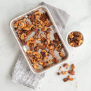 A small, rectangular, natural silver aluminum baking sheet with an embossed chevron or prism grid pattern on the interior surface