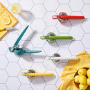 A side view of a teal-colored Chef'n FreshForce Lemon Squeezer, showcasing its ergonomic design with two long handles, and visible chrome-plated metal components at the hinge and pressing mechanism.