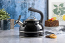 A black Kenmore Elite Costner whistling tea kettle with a polished stainless steel band at its base and a heat-resistant black Bakelite handle.