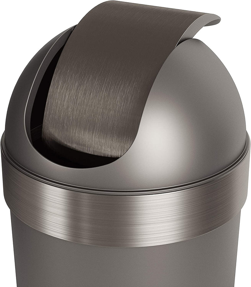 Umbra trash can standing beside a white panel wall