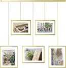 Umbra Exhibit photo display with five hanging frames (two 4x6 and three 5x7) suspended from a brushed metal ledge, on a white background.