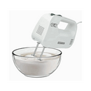 White Dominion hand mixer blending batter in a glass bowl