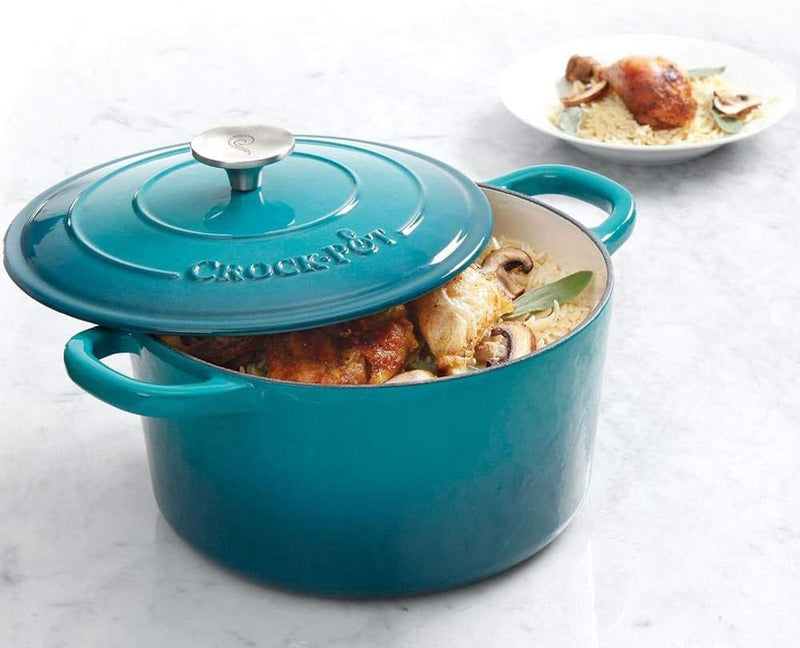 Dutch oven filled with cooked chicken and vegetables on white background
