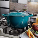 Teal enameled Crock-Pot Dutch oven on stovetop surrounded by fresh vegetables