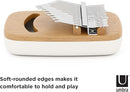 An elevated, side-angle view of an Umbra Strumba Kalimba. This musical instrument features a light-colored wooden top with a crescent-shaped sound hole and a series of white-tipped metal tines. The tines are engraved with musical notes or numbers. The base of the instrument is a smooth, rounded, off-white or cream color. The image is set against a plain white background. The "U umbra" brand logo is visible in the bottom right corner.