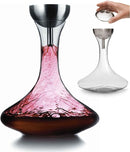 A glass wine decanter with a wide base and narrow neck, shown with a stainless steel "wine shower" funnel and a detached fine-mesh sediment strainer.