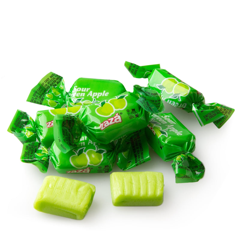 A single Zaza Sour Green Apple Chew, individually wrapped in bright green packaging with apple illustrations, alongside an unwrapped chewy candy showcasing its soft, tangy texture.