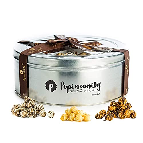 A round silver tin of Popinsanity Gourmet Popcorn, featuring three flavors—caramel, cookies & cream, and dark chocolate drizzle—elegantly wrapped with a branded brown ribbon, perfect for gifting.