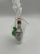A gift set containing a mini bottle of Smirnoff vodka, a measuring shot glass labeled "ONE SHOT," and two green wrapped sour apple candies.