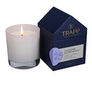 The Trapp No. 25 Lavender de Provence House Box Candle burning, creating a warm ambiance next to its elegant house-shaped packaging.