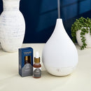 Lifestyle image of the Trapp No. 77 Palo Santo Diffuser Oil with its packaging, placed next to a teardrop-shaped ultrasonic diffuser.