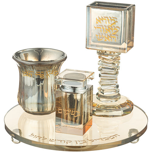 A luxurious gold-accented crystal Havdalah set featuring a round engraved base, a Kiddush cup, a square spice box, and a tall candle holder. The set is adorned with elegant gold Hebrew inscriptions, adding a refined touch to the Havdalah ceremony.