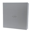 A sleek, square Art Judaica gift box in light gray with the brand's logo printed in the center. The box is designed for packaging Judaica items, providing an elegant and protective presentation.